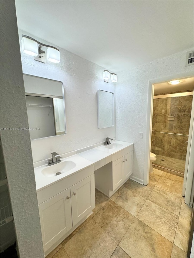 bathroom with vanity, toilet, and a shower with door