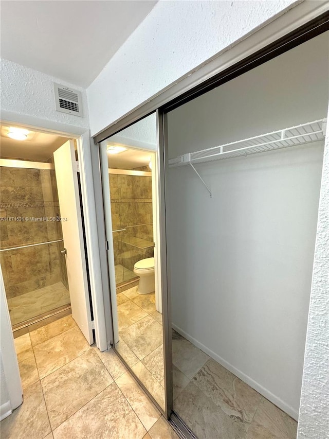 bathroom with toilet and a shower with shower door