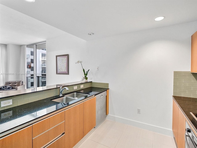 kitchen with appliances with stainless steel finishes, backsplash, light tile patterned flooring, and sink