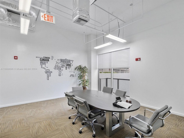 home office with a towering ceiling and carpet