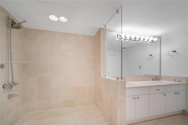 bathroom featuring tiled shower, tile patterned floors, and vanity