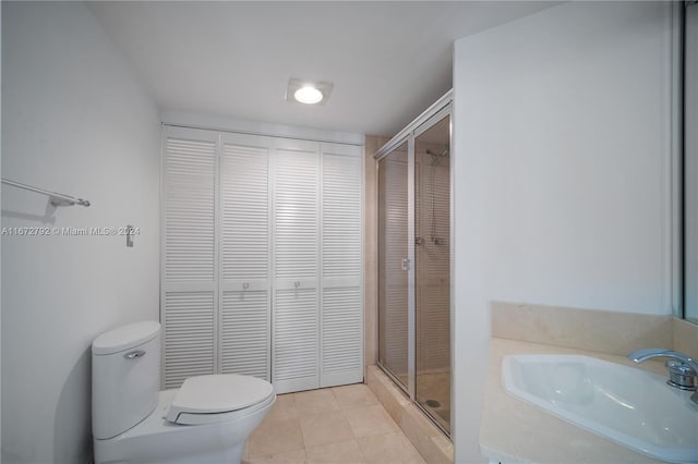 bathroom with walk in shower, tile patterned floors, sink, and toilet