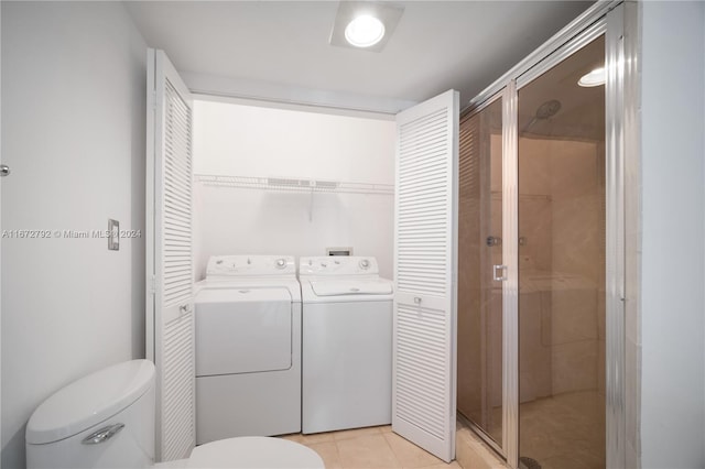 bathroom featuring separate washer and dryer, tile patterned floors, a shower with door, and toilet