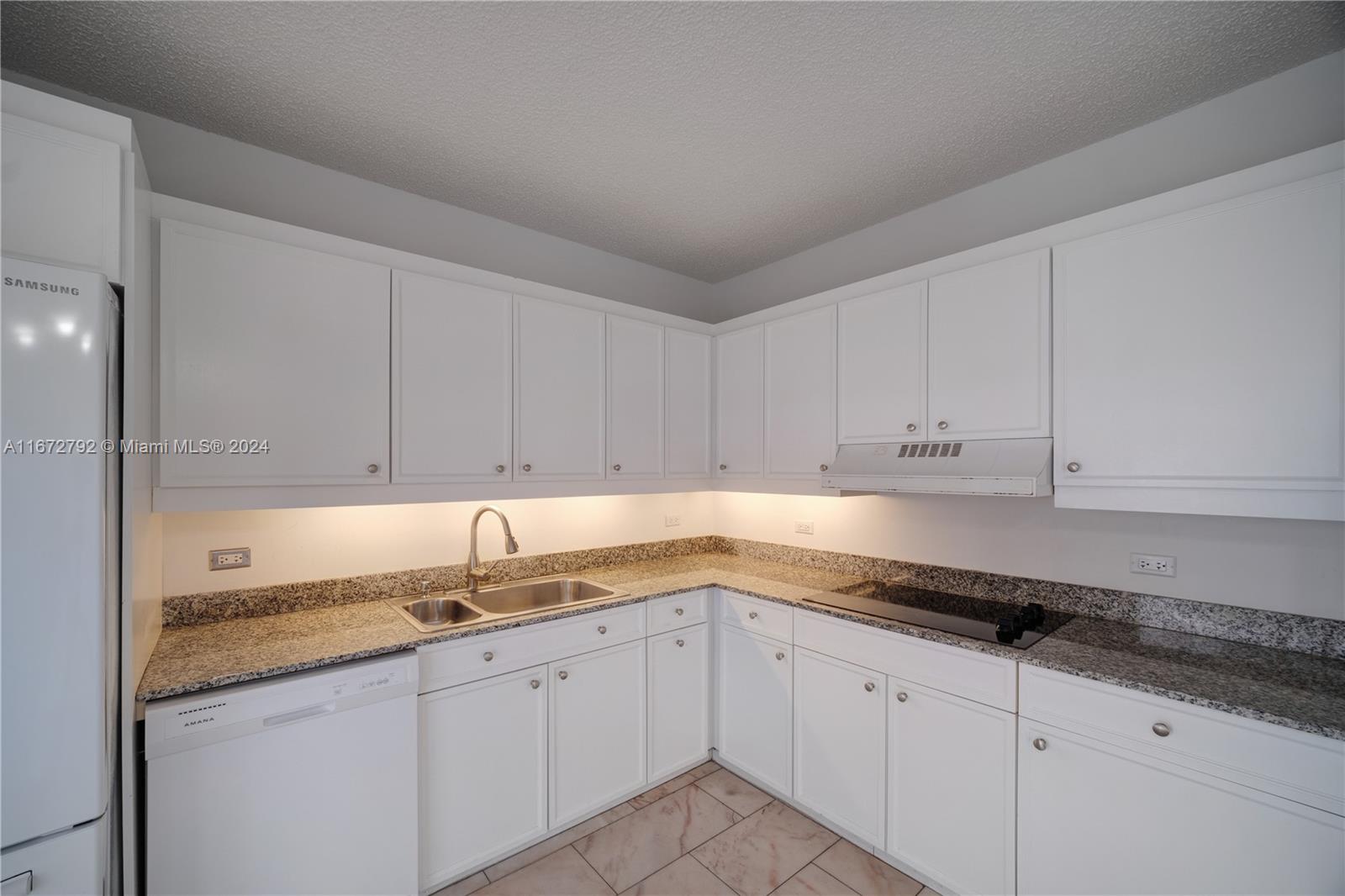 kitchen with white cabinets, a textured ceiling, sink, and white appliances