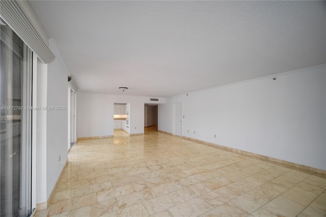 8855 Collins Ave Unit 2D, Surfside, FL 33154 - empty room featuring light marble finish floors, a textured ceiling, and baseboards