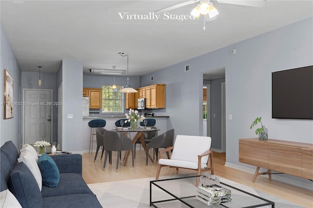 living room featuring ceiling fan and light wood-type flooring