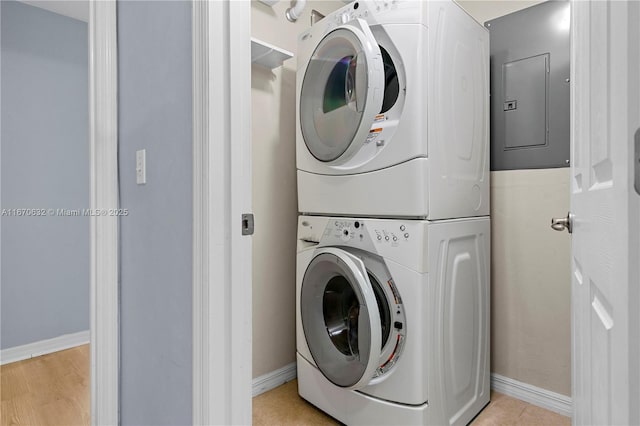 clothes washing area featuring stacked washer and dryer and electric panel