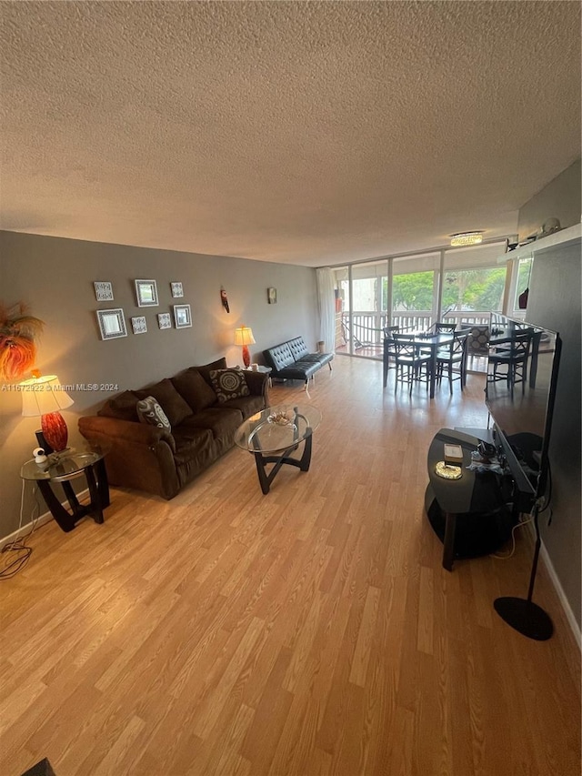 unfurnished living room featuring light wood-type flooring and a textured ceiling