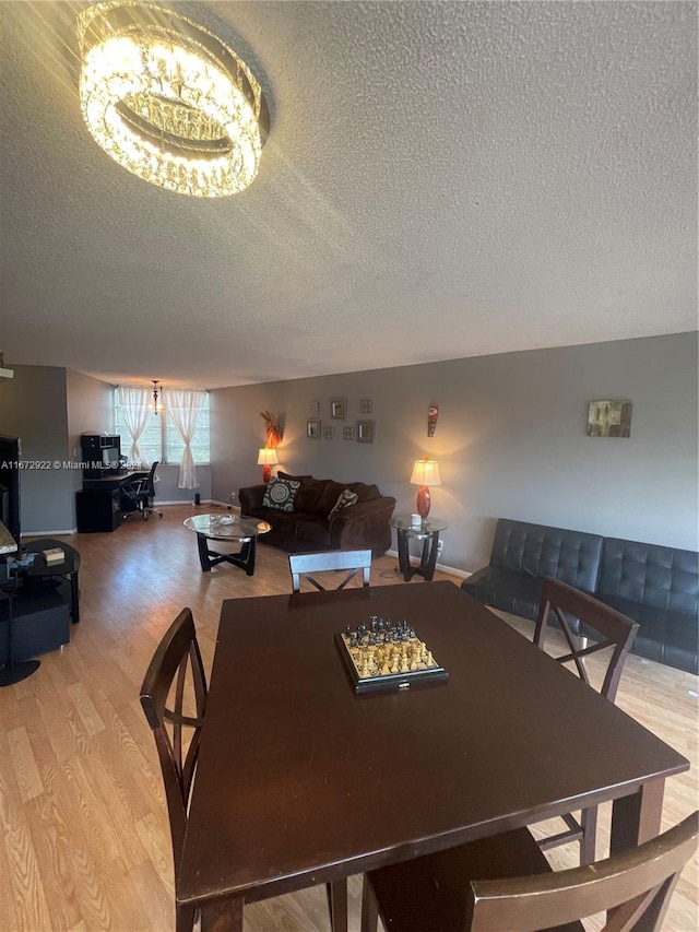 dining room with a textured ceiling and light hardwood / wood-style floors