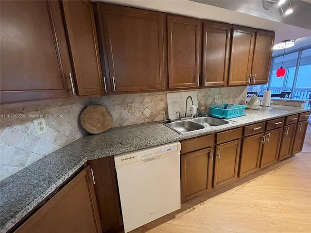 kitchen featuring light hardwood / wood-style flooring, dishwasher, backsplash, and sink