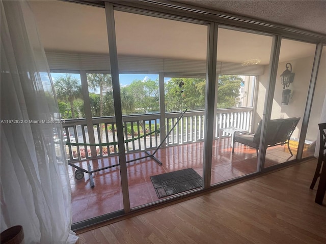 doorway with expansive windows and hardwood / wood-style flooring