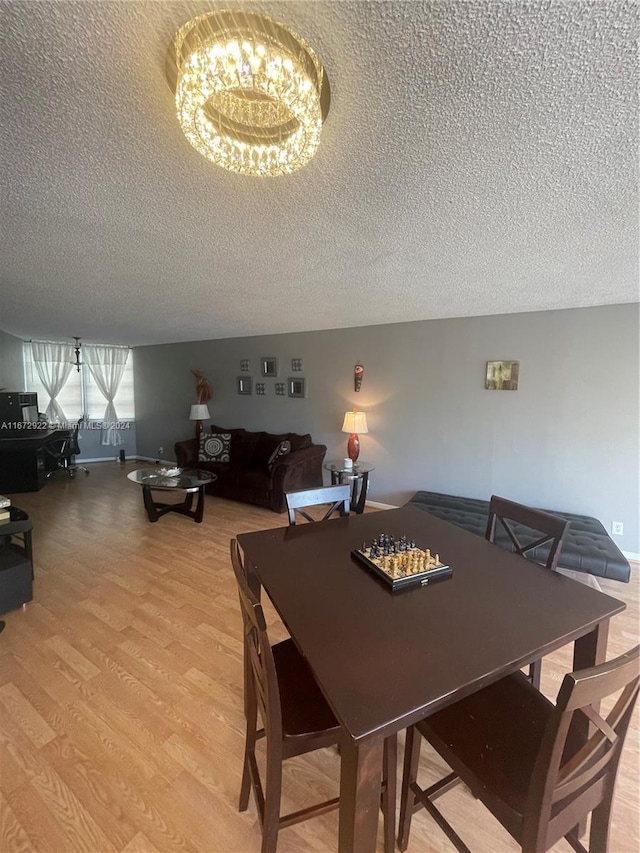 dining space with light hardwood / wood-style flooring and a textured ceiling