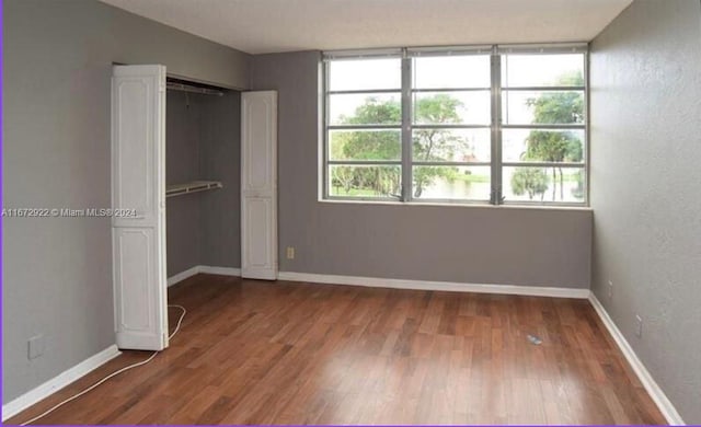 unfurnished bedroom featuring multiple windows and hardwood / wood-style flooring