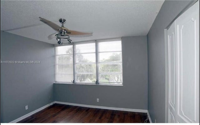 unfurnished room featuring ceiling fan, a textured ceiling, and dark hardwood / wood-style floors