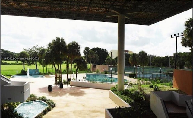 view of pool with ceiling fan, pool water feature, and a patio area