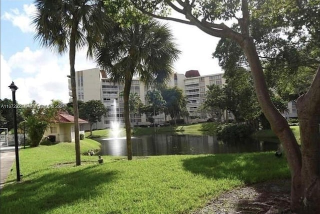 view of community featuring a lawn and a water view