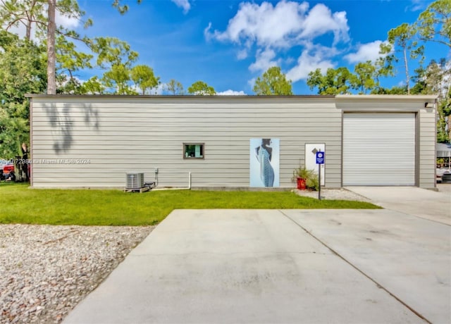 garage featuring central air condition unit and a yard