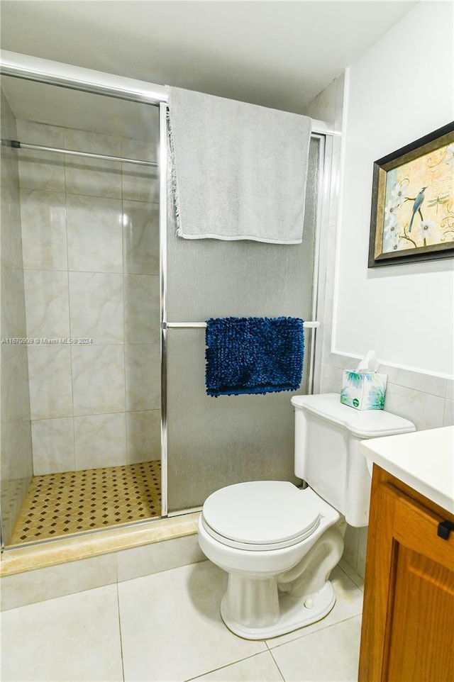 bathroom with walk in shower, tile patterned flooring, vanity, and toilet