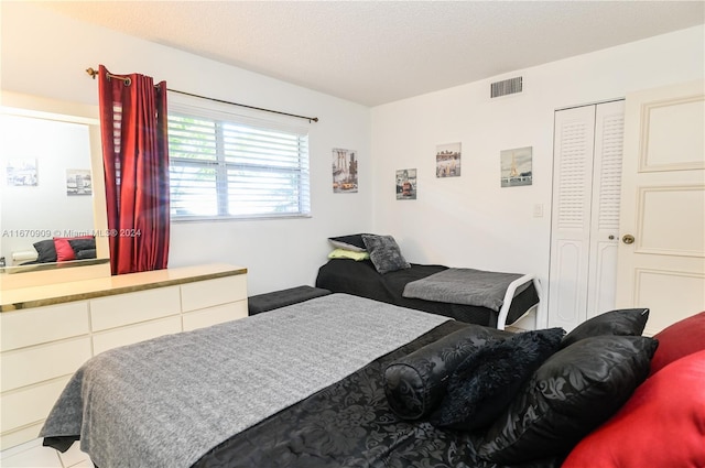 bedroom featuring a textured ceiling and a closet