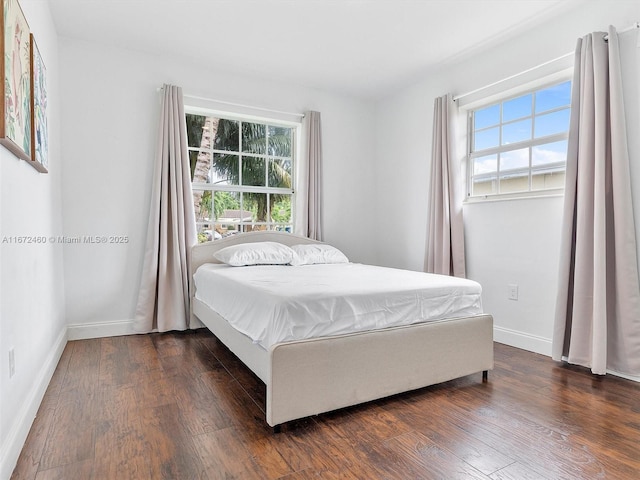 bedroom with dark hardwood / wood-style floors