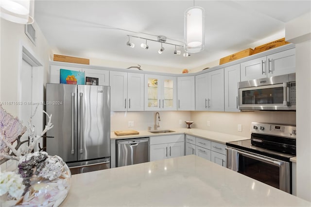 kitchen featuring appliances with stainless steel finishes, sink, and decorative light fixtures