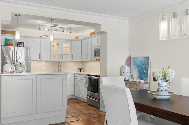 kitchen with appliances with stainless steel finishes, decorative backsplash, pendant lighting, and white cabinets