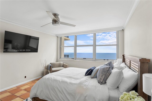 tiled bedroom featuring ceiling fan, crown molding, and a water view