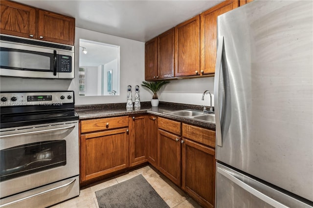 kitchen with appliances with stainless steel finishes, light tile patterned floors, and sink