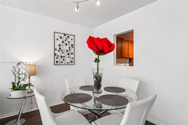 dining space featuring a textured ceiling and dark hardwood / wood-style floors