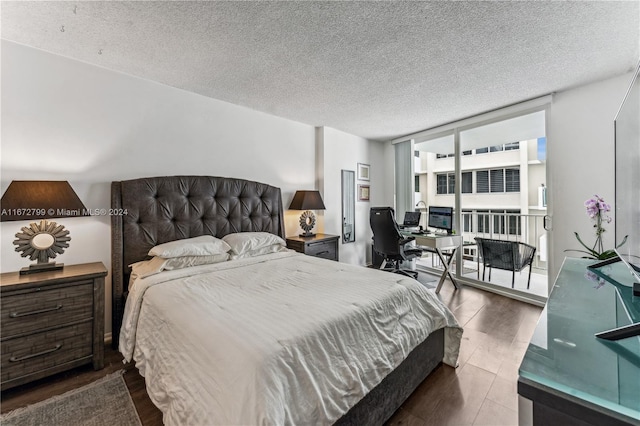 bedroom featuring a textured ceiling, a wall of windows, and dark hardwood / wood-style flooring