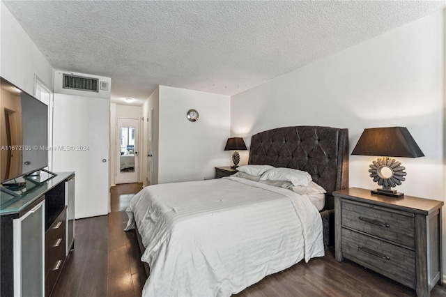 bedroom featuring a textured ceiling and dark wood-type flooring