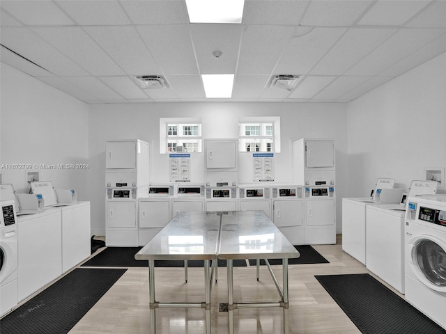 laundry room with washing machine and clothes dryer, light wood-type flooring, and stacked washer / dryer