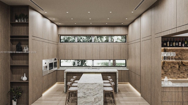 interior space with light hardwood / wood-style flooring, built in features, and a breakfast bar