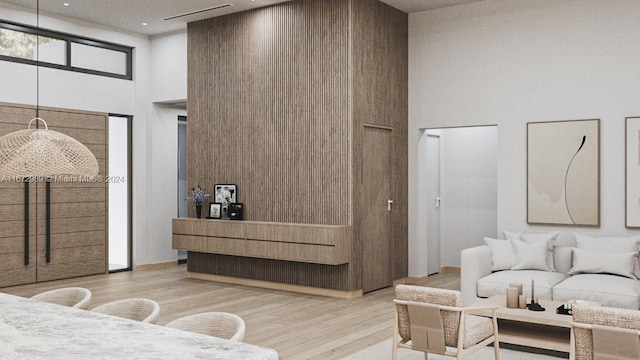 bedroom featuring a towering ceiling and light hardwood / wood-style floors