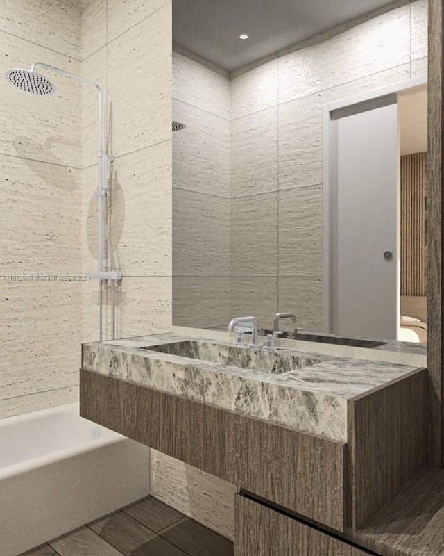 bathroom featuring tile walls, tiled shower / bath combo, and vanity