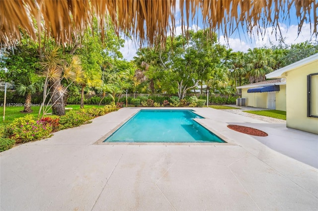 view of swimming pool with central AC unit and a patio