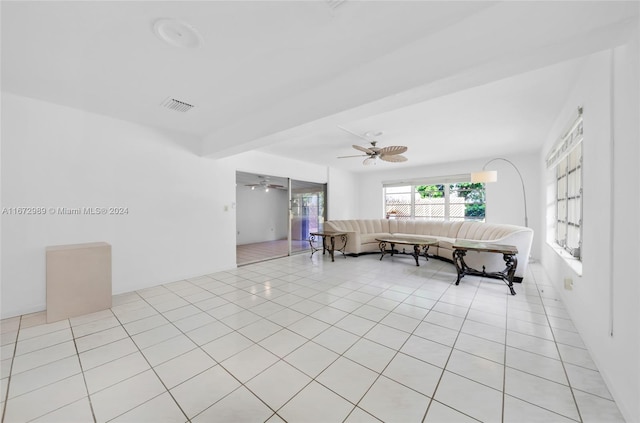 unfurnished living room featuring ceiling fan and light tile patterned floors