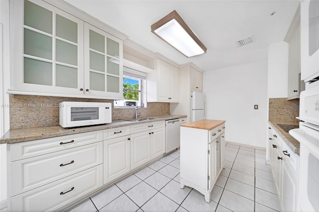 kitchen featuring white cabinetry, tasteful backsplash, white appliances, butcher block counters, and light tile patterned floors