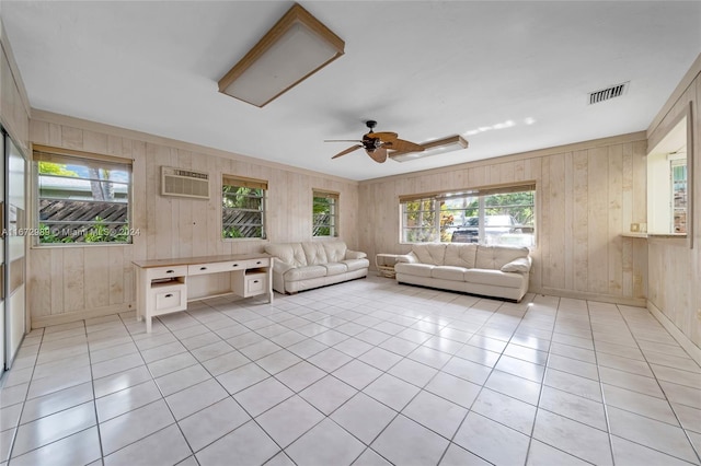 unfurnished living room with built in desk, light tile patterned flooring, wooden walls, and ceiling fan