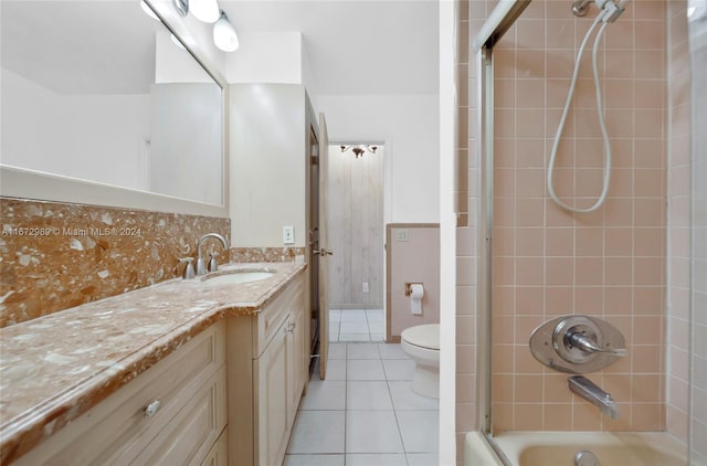 full bathroom with tiled shower / bath, vanity, tile patterned floors, tile walls, and toilet