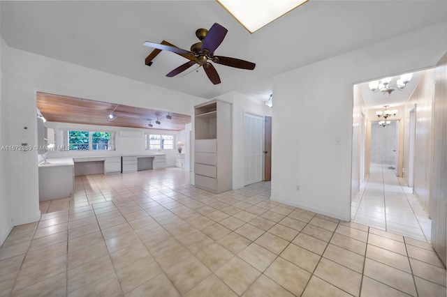 unfurnished living room with ceiling fan with notable chandelier and light tile patterned floors