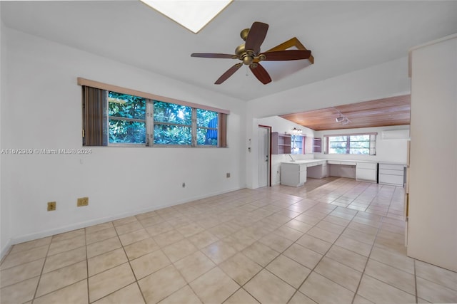 unfurnished living room featuring ceiling fan, vaulted ceiling, and light tile patterned floors