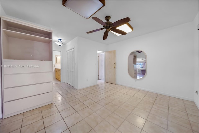 tiled spare room with ceiling fan