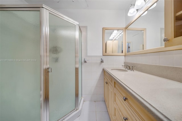 bathroom featuring tile walls, tile patterned floors, walk in shower, and vanity