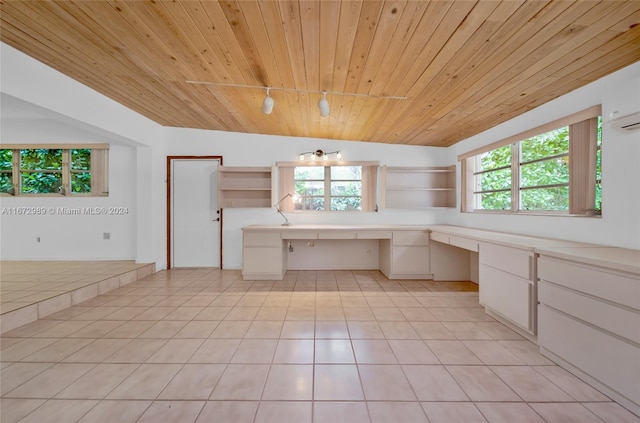 kitchen with built in desk, wooden ceiling, plenty of natural light, and white cabinets