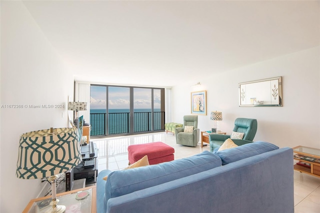 living room featuring floor to ceiling windows, a water view, and light tile patterned floors