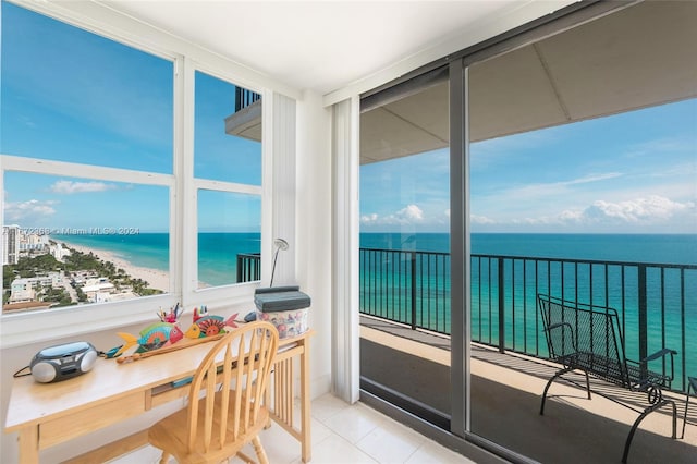 sunroom / solarium with a water view and a view of the beach