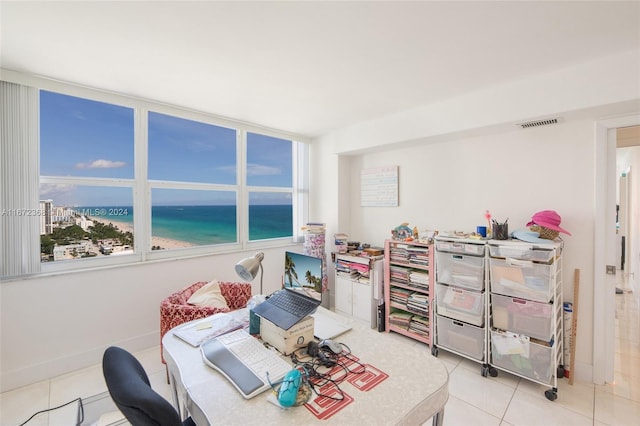 tiled bedroom featuring a beach view and a water view