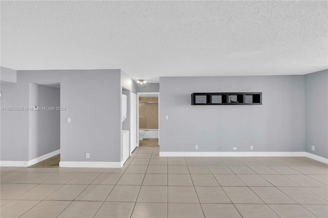 unfurnished room featuring a textured ceiling and light tile patterned flooring