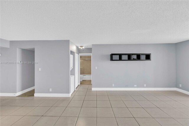 3300 NE 192nd St Unit 1108, Aventura, FL 33180 - spare room featuring a textured ceiling, light tile patterned flooring, and baseboards
